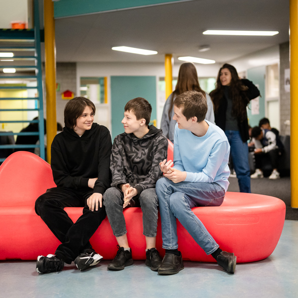 Foto van jongeren zitten op een bank in een school