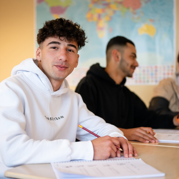 Foto jongeren zittend aan een tafel in een schoollokaal