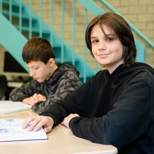 Foto jongeren zittend aan een tafel in een schoollokaal